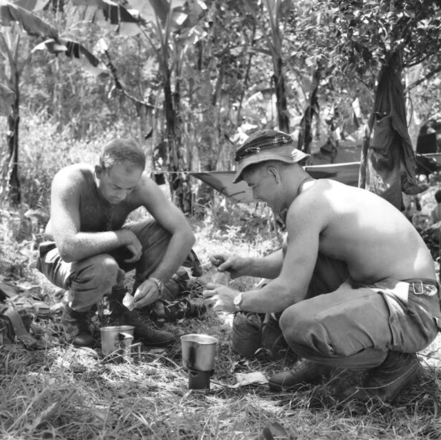 Black and white photograph of two Australian soldiers in the field in Vietnam brewing a cup of tea, November 1967